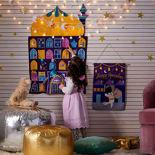 Little girl takes out a treat from her Ramadan calendar.