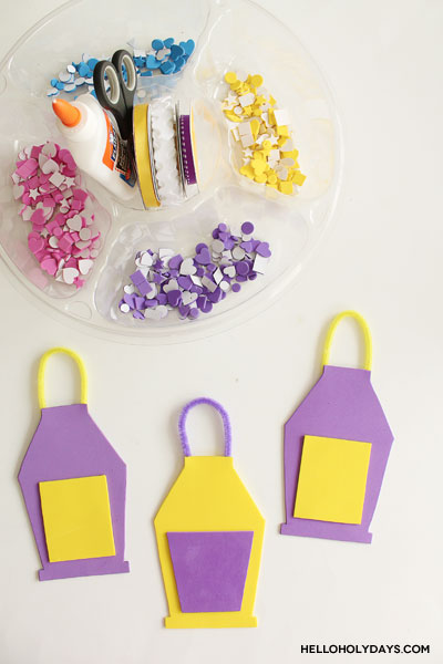 A tray of craft supplies is laid out to decorate foam lanterns for Ramadan.