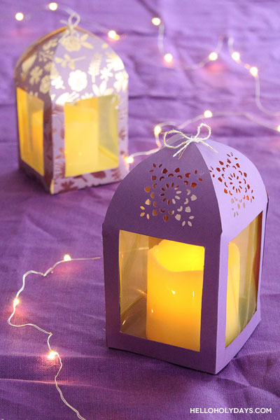 Two paper lanterns in purple color are displayed on a table for Ramadan.