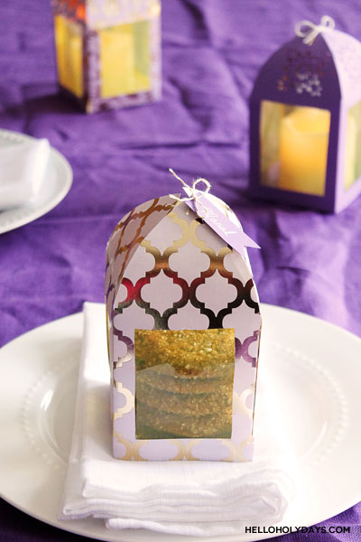 A paper lantern favor box is placed on a plate as a favor idea for parties.