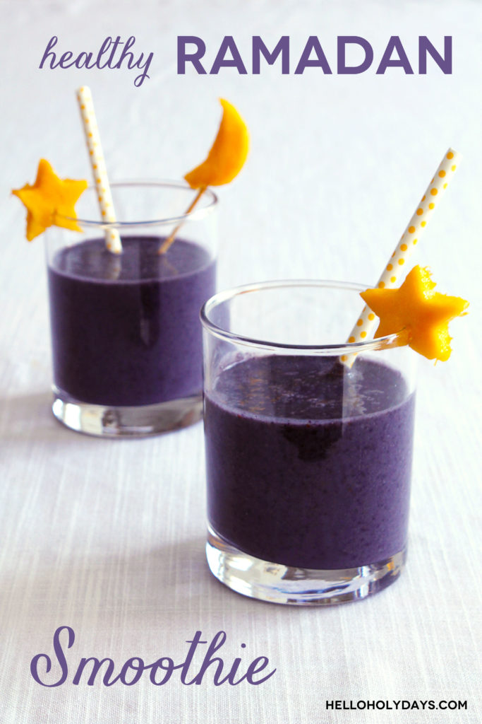 A purple colored smoothie is displayed in glasses with straw and cut yellow fruit in the shape of a moon and stars.