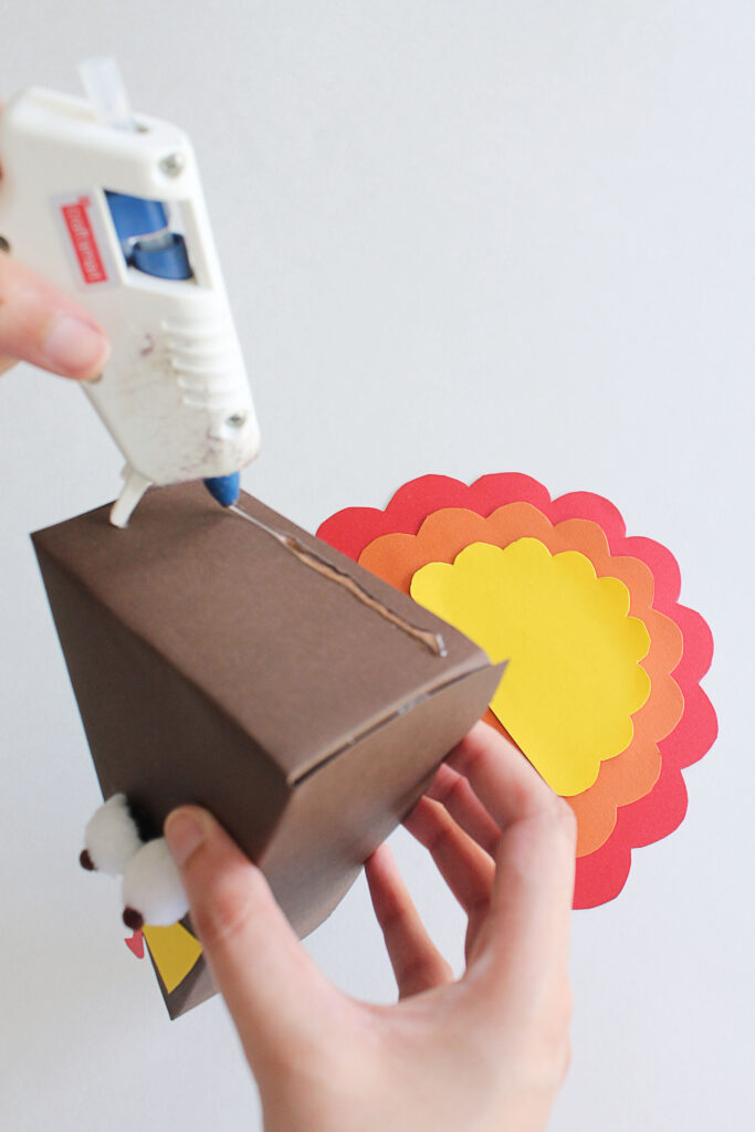 Glue the feathers to the paper box.